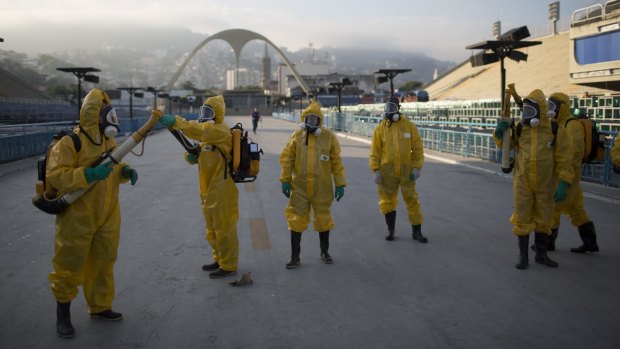 Health workers get ready to spray insecticide in Rio de Janeiro.