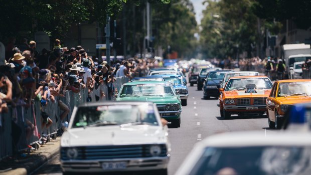 Crowds watch the Summernats 'City Cruise' pass through Canberra on Thursday.