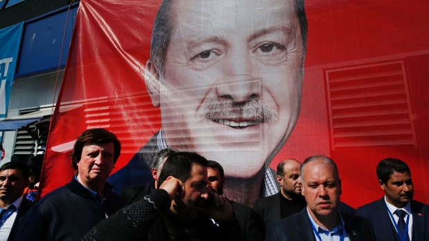 Supporters of the "Yes" campaign stand in front of a giant picture of Turkish President Recep Tayyip Erdogan.