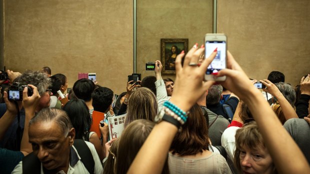 She's back there somewhere: crowds viewing the Mona Lisa at the Louvre.