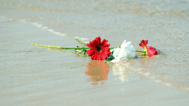 Flowers were cast into the ocean during the vigil.