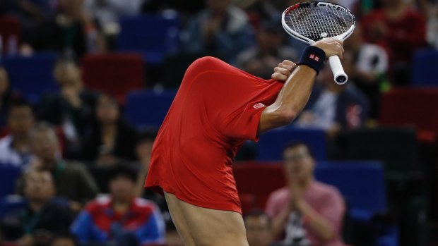 Novak Djokovic of Serbia takes off his shirt after losing a point to Roberto Bautista Agut.