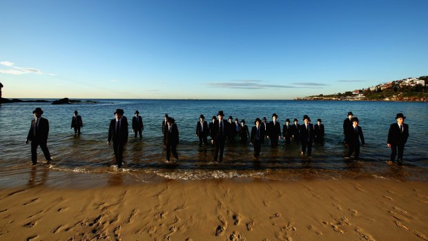Surrealist artist Andrew Baines collaborated with top-hat wearing Newington College students at Coogee Beach on Friday.