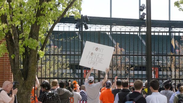 Fans stand locked out of a Baltimore Orioles baseball game against the Chicago White Sox amid unrest in Baltimore over the death of Freddie Gray at the hands of police.