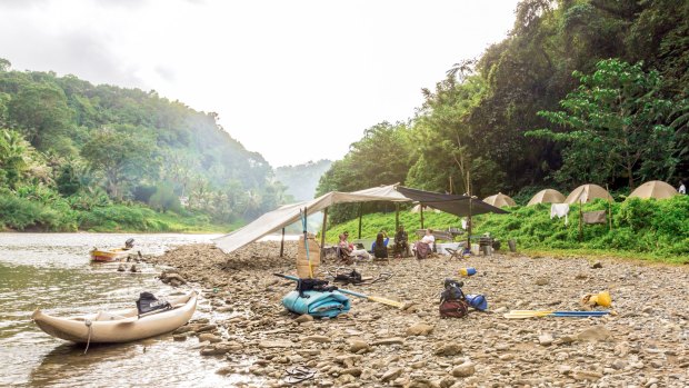 Camp is made up of tents set up by a bend of the Upper Navua.