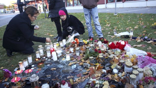 Mourners light candles outside Kronan school in Trollhattan, a day after the deadly attack. 