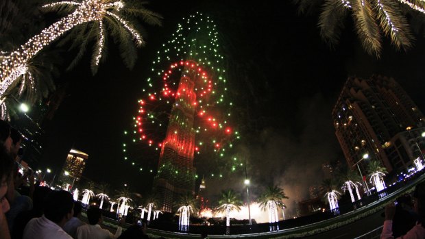 Fireworks illuminate the Burj Khalifa as a tower burns behind it in Dubai on Friday.