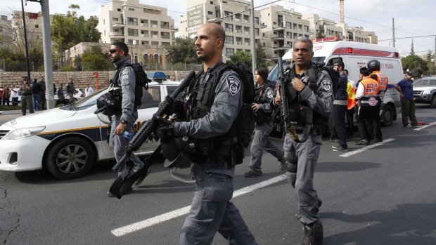 Israeli police officers head to the scene of the attack.