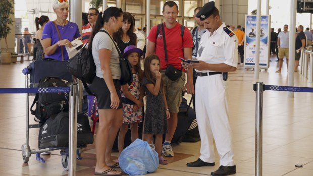 British tourists have their documents checked by Egyptian police as they prepare to be evacuated from Sharm el-Sheikh airport on Friday.