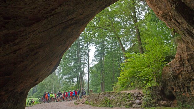 Cycling group at Latvia's Gutmanis Cave, the largest cave in the Baltics.