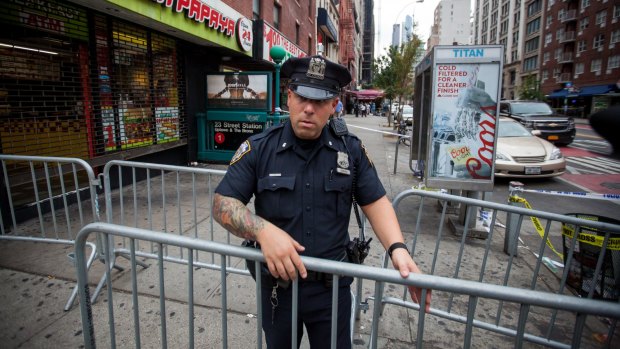 A New York City Police Department officer places barricades near the site of Saturday night's explosion in Chelsea. 