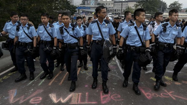 "We will be back": Hong Kong police officers clear the site.