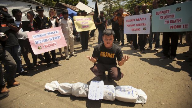 An anti-drugs protester in Cilacap prays in front of an effigy of a drug smuggler.