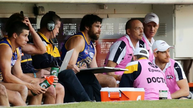 Eagles forward Josh Kennedy is checked by the doctor after sustaining an injury against the Giants.