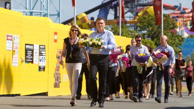 Dreamworld chief executive Craig Davidson and his employees leave flowers at the site on Wednesday.