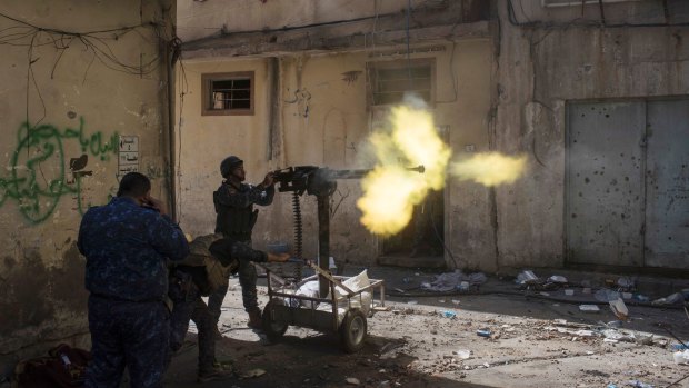Policemen fire towards Islamic State positions in on the western side of Mosul, Iraq.