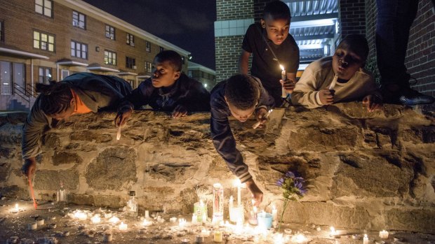 After a protest march, candles are lit at a makeshift memorial site for Freddie Gray, who suffered fatal injuries while in police custody.