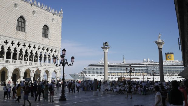 A cruise ship passes by St. Mark's Square. Locals want large ships banned from the lagoon.
