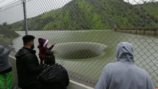 People stop to watch water flow into the iconic Glory Hole spillway.