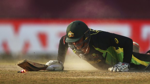 Sliding in: Usman Khawaja is run out by New Zealand's Grant Elliott in Dharamsala.