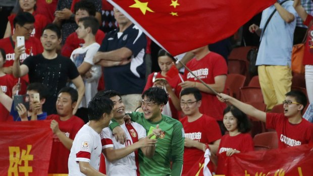 Proud night: China's Hao Junmin, Zheng Zhi and Wang Dalei soak up the atmosphere after defeating Uzbekistan.