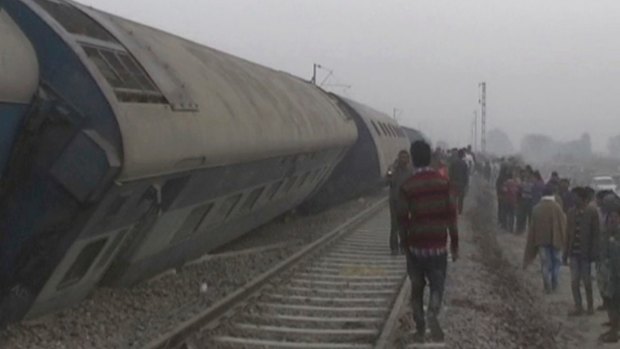 People gather at the site of a train accident near Pukhrayan, about 270 kilometres from Allahabad, on Sunday.