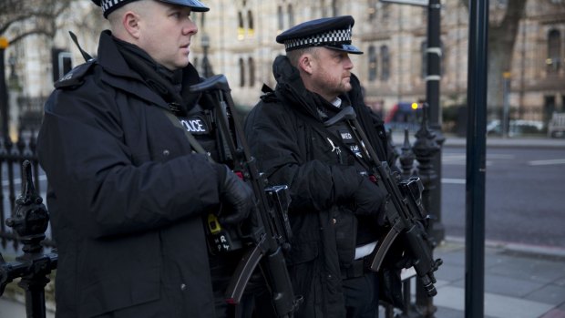 Armed British police officers stand guard near the French Institute and French School in London.