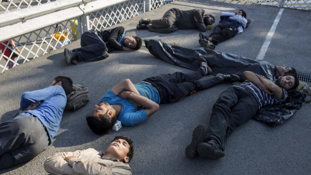 Migrants sleep at a parking lot near Belgrade's main bus and train station, in Serbia on Thursday.