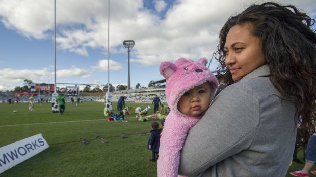 Josh Papalii's mother Mespa Salesa, with his daughter, Khalani-Rose Papalii, watch Raiders players warm up from the side lines.