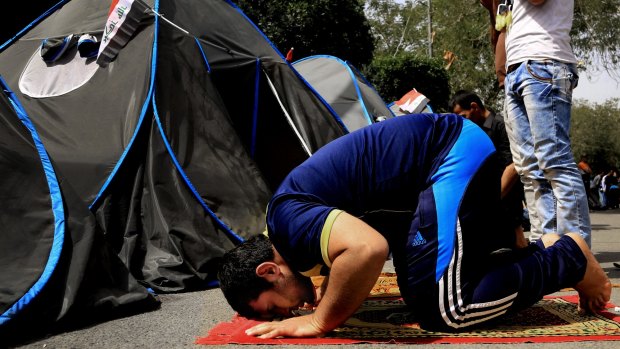 A Sadr supporter takes time to pray at a protest camp on the edge of the Green Zone.