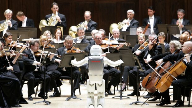 Honda's ASIMO robot conducts the Detroit Symphony Orchestra as it performs "Impossible Dream".