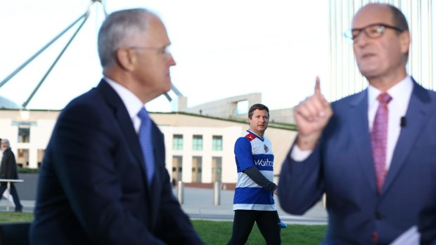 Former member for Hindmarsh Matt Williams walks past while Prime Minister Malcolm Turnbull is interviewed by David Koch following the 2016 budget.