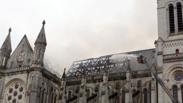 Firefighters put out the fire in a basilica in Nantes, western France, Monday.