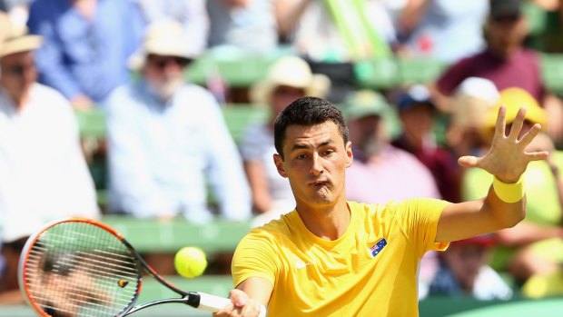 Bernard Tomic of Australia plays a forehand in his match against Jack Sock of the United States.