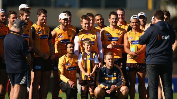 A happy bunch: Hawthorn players pose for a photo with a young fan at Waverley Park on Friday.