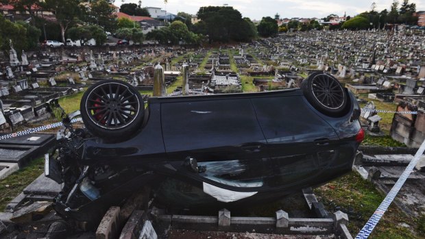 The Mercedes fell about two metres before flipping onto its roof and coming to rest upside down on a grave.