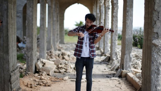 Ameen Mukdad, a violinist from Mosul who lived under IS rule for two and a half years, performs at Nabi Yunus shrine in eastern Mosul on Wednesday.