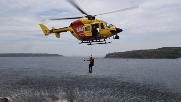 Rescue crewman John Molnar offers a thumbs up signal as he descends during a winch training exercise at Cape Banks.