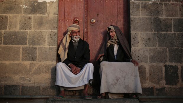 Yemeni men chat while sitting in front of their house in the old city of Sanaa, Yemen, in November 2016.