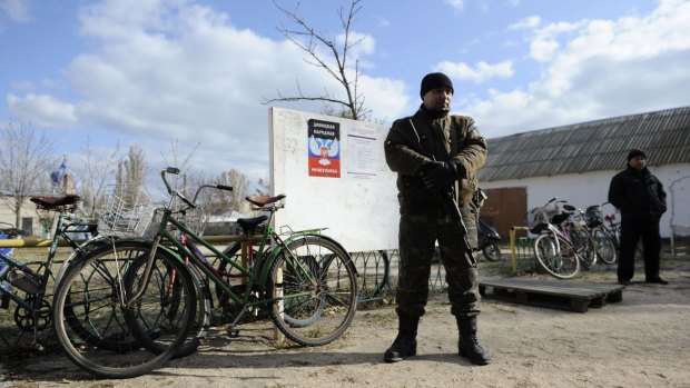 A pro-Russian militant guards a polling station in Novoazovsk, eastern Ukrainian.