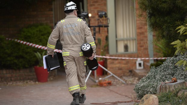 A fire investigator carries a hoverboard of the same make as the one that caused a house fire in Melbourne. 