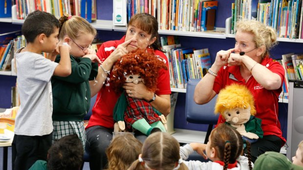 Rachel Mills (left) and Donna Rees teach students at Dubbo West Primary School how to blow their nose correctly. They are pictured with puppets, Lucy and Snotty Sam.