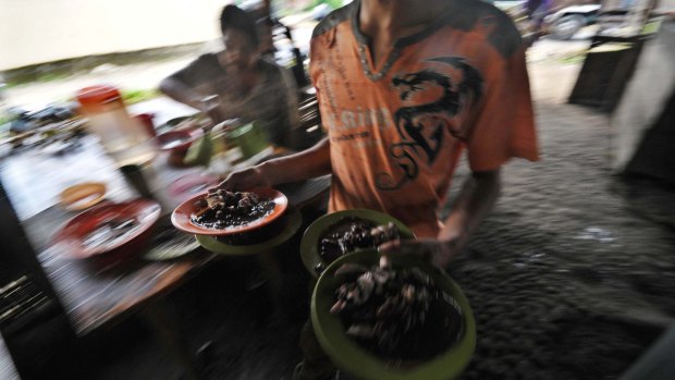 Waiter prepare roasted dog meat in traditional restaurants in Kaban Jahe, North Sumatra, Indonesia Dog meat is prepared and served in traditional restaurants in Kaban Jahe, North Sumatra, Indonesia.