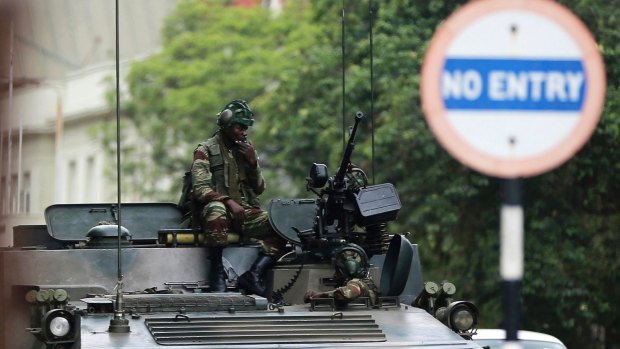 Soldiers sit on a military vehicle parked on a street in Harare, Zimbabwe, on Thursday.