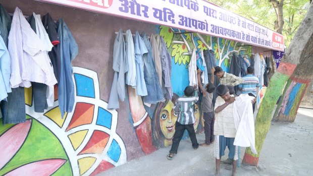 Children help themselves to donated items at the Wall of Kindness in Bhilwara, India.
