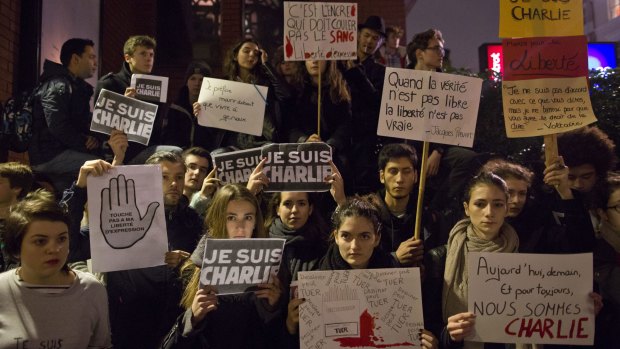 People hold up "Je Suis Charlie" and other placards at a vigil outside The French Institute in London on Friday.
