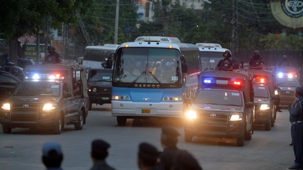 Pakistani security personnel escort buses carrying the Zimbabwe and Pakistani cricket teams as they leave a practice session at the Gaddafi Cricket Stadium in Lahore.