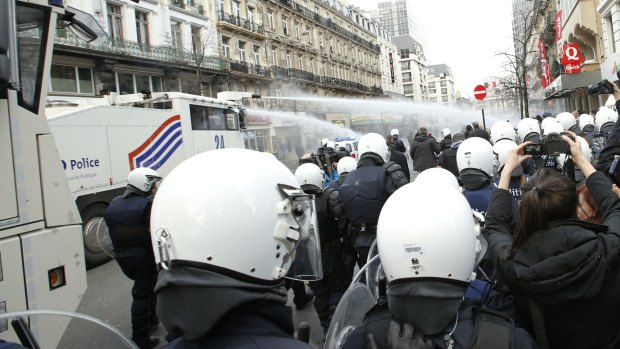 Police use water cannon to try to disperse demonstrators at the site of one of the memorials to the victims of the recent Brussels attacks.