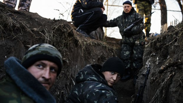 Pro-Russian rebels sit in a trench near the village of Frunze, eastern Ukraine.