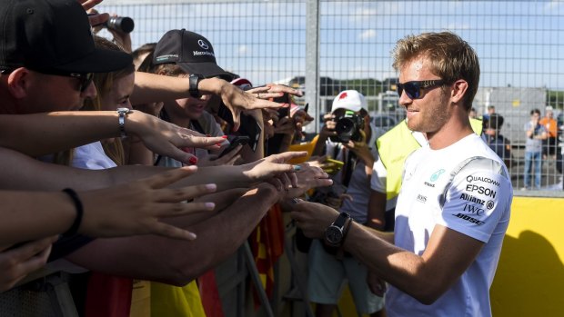 Staying put: Nico Rosberg signs autographs in Budapest on Thursday.